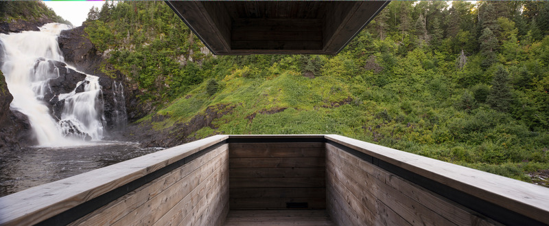 Press kit | 1640-01 - Press release | Territories and Landscapes Exhibition in Paris by Atelier Pierre Thibault - Atelier Pierre Thibault - Event + Exhibition - <p>Belvedere of the Val-Jalbert hydroelectric plant (2015), Saguenay-Lac-Saint-Jean<br></p><p>The hydroeletric plant is located in a deserted industrial village turned into a touristic destination. Its strategic site, at the foot of the Ouiatchouan falls, demanded to reconcile the industrial nature of the project with the imperative to protect a precious heritage.</p><p>The plant was therefore developed to highlight the touristic pathway, using its capacity to showcase the falls that gave the village its first reason of being. Covered by a larch lathing filtering light and intercepting frost, the concrete building appears partially buried. Its technical language, brutal yet delicate, evokes the sobriety of industrial structures. Perched above the empty air, cantilever valconies punctuate the walkaway and expose the visitors to views of the fall, the river and the historical mill.</p> - Photo credit: Alain Laforest