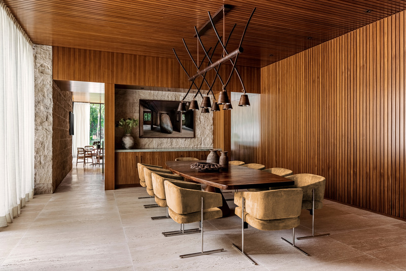 Dossier de presse | 2757-37 - Communiqué de presse | Strang Design Completes Modernist Home with Brazilian Twist - Strang Design - Architecture résidentielle -  While the home's palette is predominantly earth-tone, abundant teak paneling, as seen here in the dining room, provides pops of dramatic contrast.  - Crédit photo : Kris Tamburello