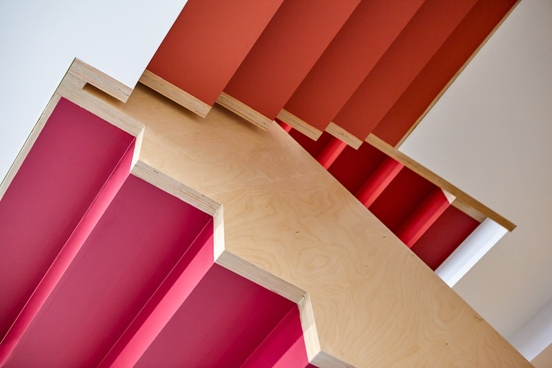 Dossier de presse | 1513-19 - Communiqué de presse | Dubbeldam Office - Dubbeldam Architecture + Design - Architecture commerciale -  Views of the angular Baltic birch staircase upon entry. A gradient of reddish hues provides a colourful journey to the building’s upper floors, transforming an economic material and setting the tone for the building’s interior character.<br>  - Crédit photo : Scott Norsworthy