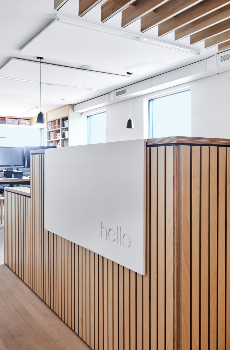 Dossier de presse | 1513-19 - Communiqué de presse | Dubbeldam Office - Dubbeldam Architecture + Design - Architecture commerciale -  Elegant and playful graphics in the Dubbeldam studio. A white Corian waterfall panel greets visitors with an inscribed “hello” at the reception desk.  <br>  - Crédit photo : Scott Norsworthy