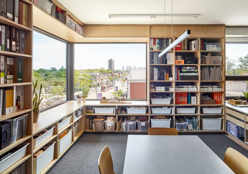 Dossier de presse | 1513-19 - Communiqué de presse | Dubbeldam Office - Dubbeldam Architecture + Design - Architecture commerciale -   A collaboration space doubles as a library of<br>reference books and material samples on perimeter shelving with natural light pouring in from the expansive corner window cut out of the north and east façades. Transparency in both directions speaks of a connection with the community, with seemingly limitless views east down St. Clair Avenue.  <br>   - Crédit photo : Scott Norsworthy