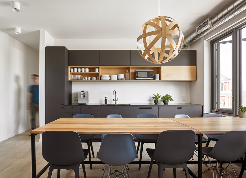 Dossier de presse | 1513-19 - Communiqué de presse | Dubbeldam Office - Dubbeldam Architecture + Design - Architecture commerciale -  The matte black cabinets in the kitchen are the ideal backdrop to team lunches and group meetings, punctuated by The Meridian light by Propeller, hanging above.  <br>  - Crédit photo : Scott Norsworthy