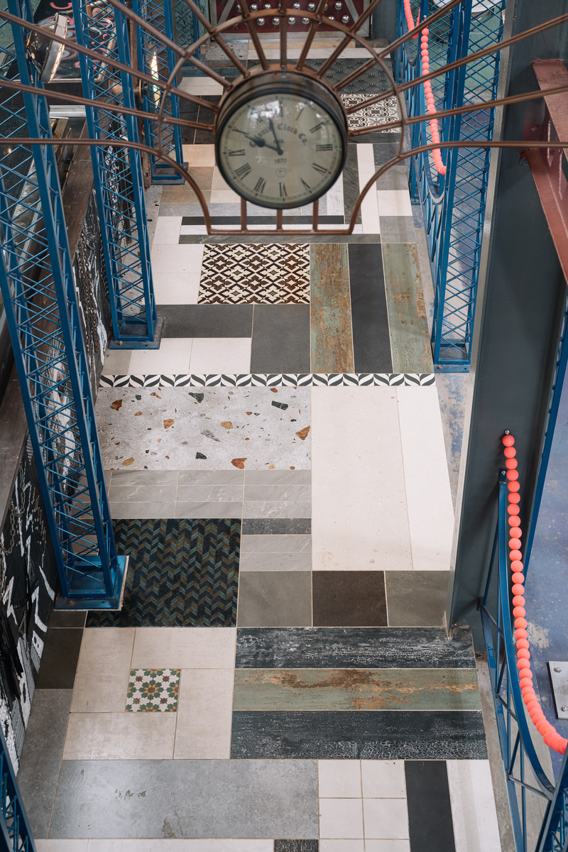 Press kit | 7002-01 - Press release | Big Top - Multitude Of Sins - Commercial Interior Design - The flooring is a mishmash of discarded samples that have been assembled in a Tetris-like fashion, procured from ceramic, tile stores, and active sites of fellow designers in the city — each sample measured, and every segment ideated individually while it forms an integral part of a larger visual tapestry. - Photo credit: <p>Ishita Sitwala</p>