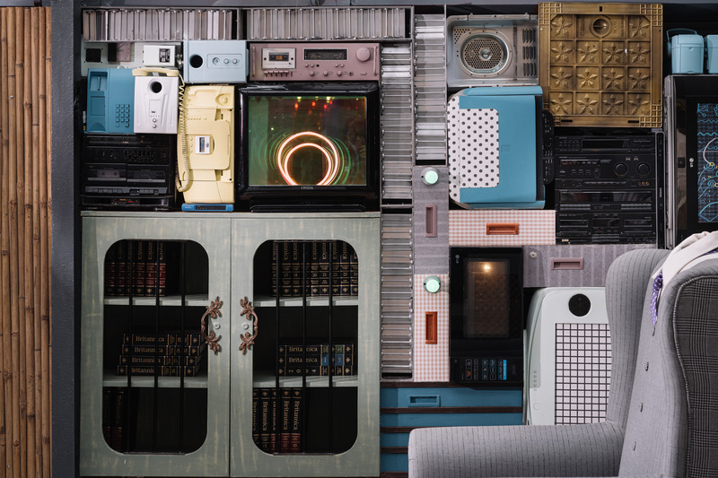 Press kit | 7002-01 - Press release | Big Top - Multitude Of Sins - Commercial Interior Design - <p>A section of the focal collage wall moving into the corporate section  is staunchly embedded with a collection of e-waste and discarded furniture, that have been pieced together to reimagine it as a haptic jigsaw. The core intention was to ensure that the waste in its originally dishevelled form now assumes the aura of a curated artistic sculpture, wherein each object has been carefully made a constituent element in the larger picture, with some elements that can be functionally utilised .The furniture here was refurbished with new fabric which sports dapper Gingham checks and pinstripes. The high-back chairs specifically seem to have gotten Barney Stinson’s memo and are ‘suited up’ to impress! </p> - Photo credit: Ishita Sitwala