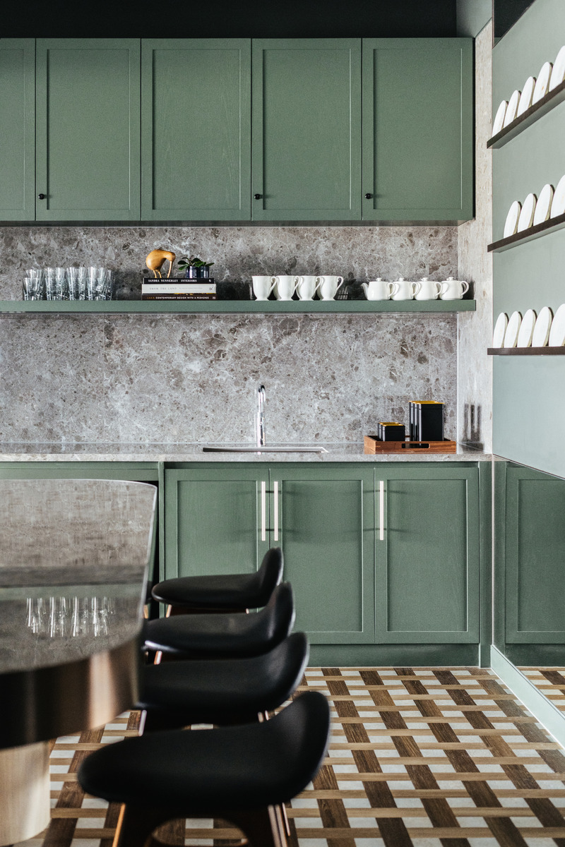 Dossier de presse | 3150-01 - Communiqué de presse | Lim + Lu Designs Rosewood Hotel's Home-Like Headquarter Office - Lim + Lu - Design d’intérieur commercial - The kitchen is adorned with patterned flooring, green cabinets and a grey stone countertop and wall. - Crédit photo : Common Studio