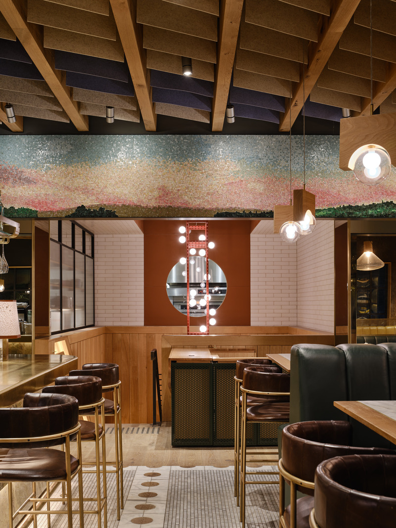 Dossier de presse | 1858-04 - Communiqué de presse | Stock T.C Transforms a Heritage Postal Station Into an Original Gastronomic Experience - Giannone Petricone Associates - Design d’intérieur commercial - The second floor organizing proscenium is rendered in meticulously laid glass mosaic tile, with a supple pink horizon line that contrasts with this floor’s otherwise earthy palette. A large keyhole offers a peek to the bustling kitchen.<br> - Crédit photo : Doublespace