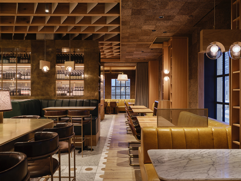 Dossier de presse | 1858-04 - Communiqué de presse | Stock T.C Transforms a Heritage Postal Station Into an Original Gastronomic Experience - Giannone Petricone Associates - Design d’intérieur commercial - Discrete and tufted golden yellow banquettes, oak shelving and cork walls sit spaced from the original exterior walls to expose the historic windows and city views.<br> - Crédit photo : Doublespace