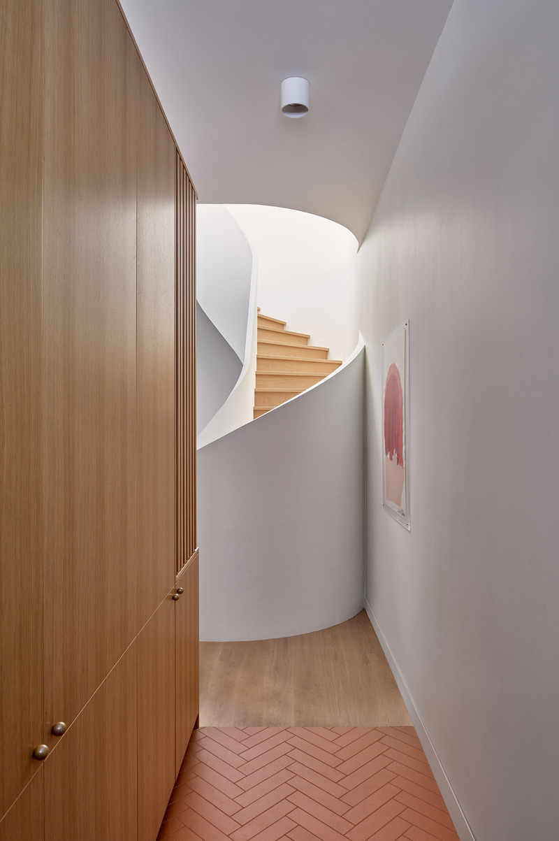 Dossier de presse | 1513-18 - Communiqué de presse | Flow House - Dubbeldam Architecture + Design - Architecture résidentielle -  Flow House was designed for an art-centric family, weaving together curved forms and the owners’ whimsical artwork and sculpture. A glimpse of the flowing staircase is viewed upon entry, framed by warm oak built-ins on one side, and a whimsical print on the other.  <br>  - Crédit photo : Riley Snelling