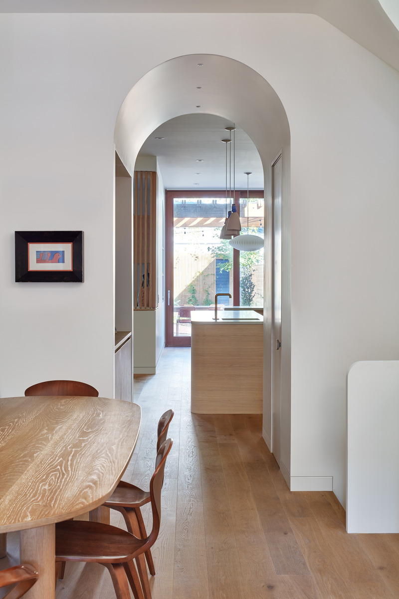 Dossier de presse | 1513-18 - Communiqué de presse | Flow House - Dubbeldam Architecture + Design - Architecture résidentielle - The dining room table, custom designed by Dubbeldam, was fabricated by Commute Home. The view through the arched interstitial bar area leads to the kitchen and floor to ceiling glass doors beyond. - Crédit photo : Riley Snelling