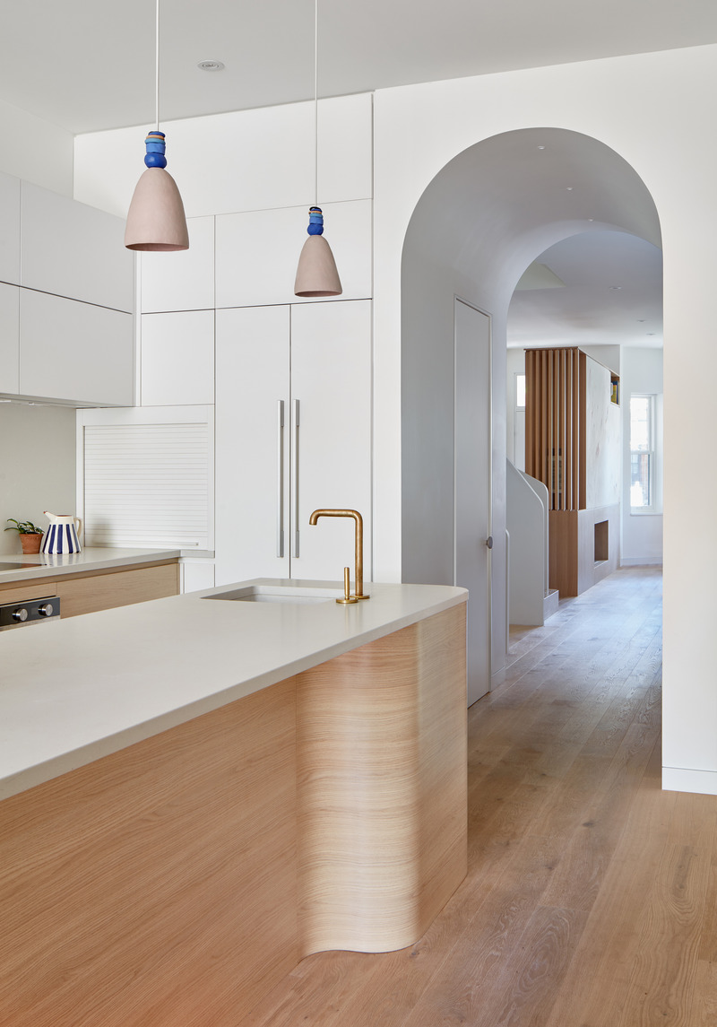 Dossier de presse | 1513-18 - Communiqué de presse | Flow House - Dubbeldam Architecture + Design - Architecture résidentielle - The curved kitchen island in white oak is topped by a matte Caesarstone counter and accented with tactile fixtures like the hand-molded clay pendant lights and antiqued brass faucets.<br style=""> - Crédit photo : Riley Snelling