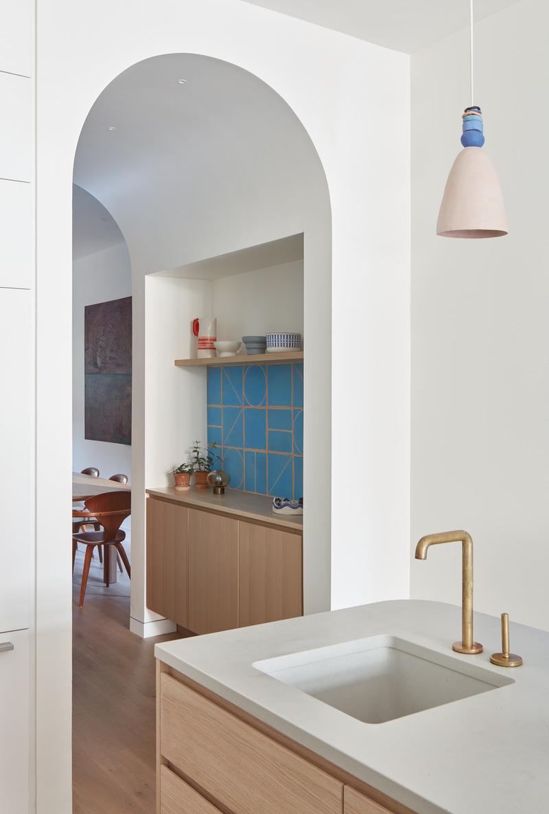 Dossier de presse | 1513-18 - Communiqué de presse | Flow House - Dubbeldam Architecture + Design - Architecture résidentielle - Hand-cast whimsical Spanish tiles line a bar alcove carved into the extruded archway that connects the dining room to the kitchen, a nod to the clients’ passion for craft. The owner’s ceramics are displayed above the bar. - Crédit photo : Riley Snelling