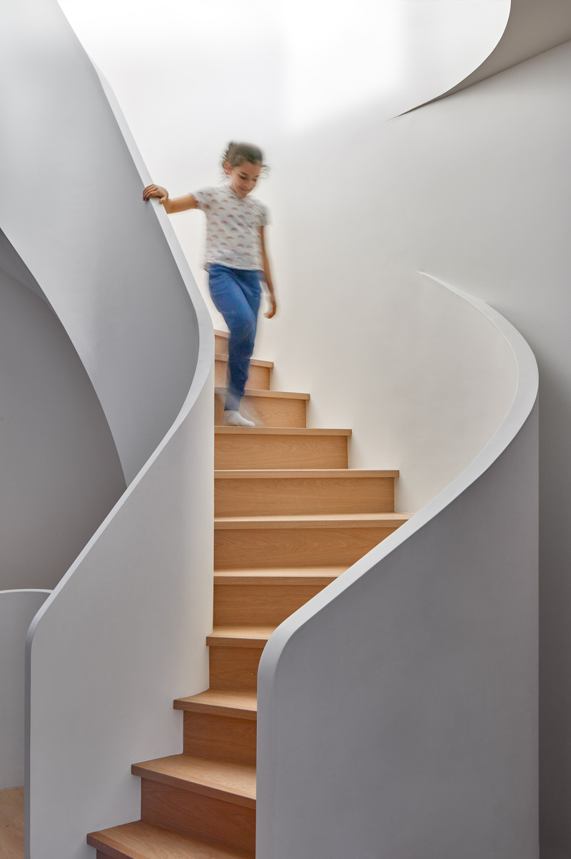 Dossier de presse | 1513-18 - Communiqué de presse | Flow House - Dubbeldam Architecture + Design - Architecture résidentielle - The curved stair guards appear as if they have been sculpted rather than built. Awash in natural light from the skylight above, the winding balustrade casts shifting shadows throughout the day. - Crédit photo : Riley Snelling