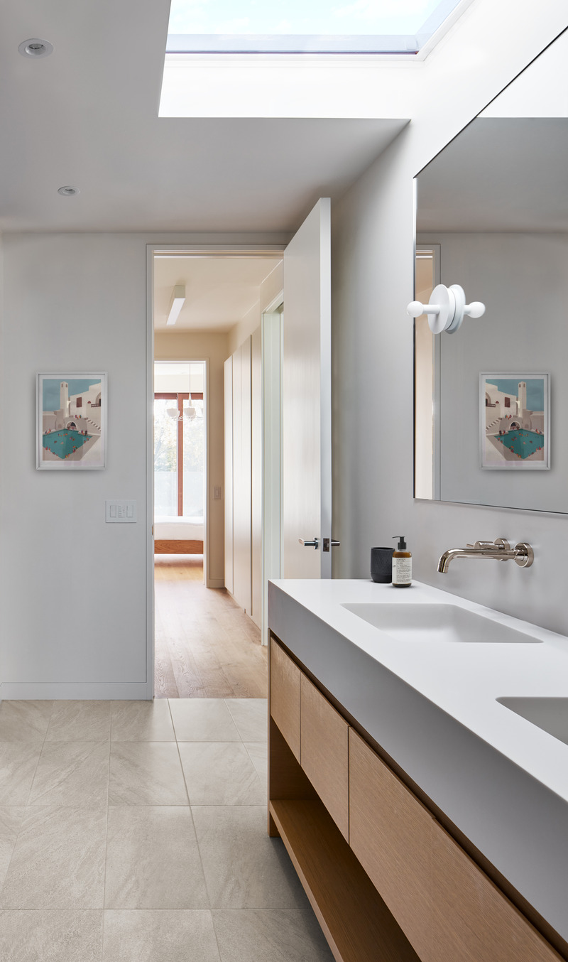 Dossier de presse | 1513-18 - Communiqué de presse | Flow House - Dubbeldam Architecture + Design - Architecture résidentielle - The ensuite bathroom is imbued with natural light from a large skylight over the molded Corian vanity. A view through the walk-in closet leads to the principal bedroom and roof deck beyond. - Crédit photo : Riley Snelling