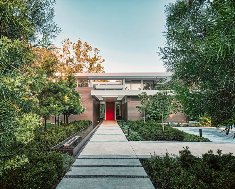Press kit | 2757-38 - Press release | Swatt Miers Architects Serves Up California Cool with a Warm Modern Twist - Swatt Miers Architects - Residential Architecture -  Owyang House:  The entry sequence to this new, two-story residence is a study in expansion and compression: The pathway, flanked by a long, linear infinity-edge water feature, opens to the sky, while a long, low steel canopy compresses the exterior entrance space and focuses attention on the dramatically hued entry door.<br style="">  - Photo credit: Tim Griffith