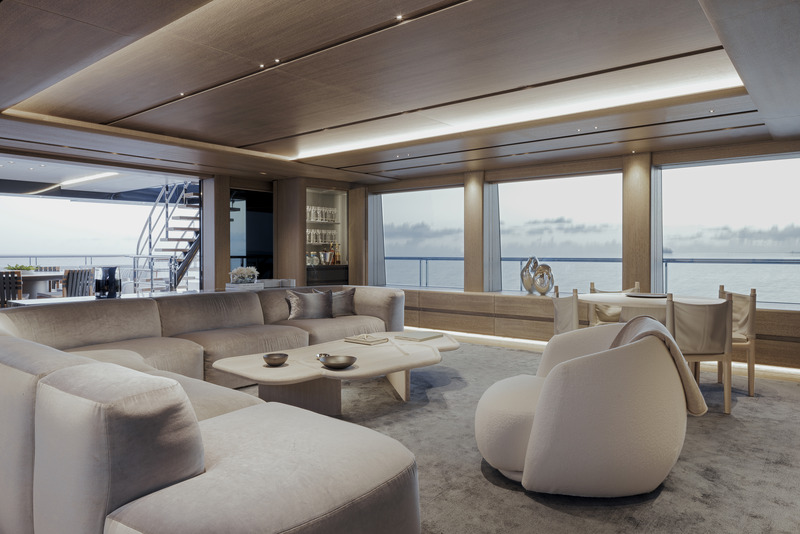 Press kit | 889-06 - Press release | BURDIFILEK Sets Sail Into the World of Luxury Yachting With Entourage - BURDIFILEK - Residential Interior Design - The family room on the bridge deck introduces pewter-toned furnishings, a muted blue carpet and oak wood cabinetry and ceiling. - Photo credit: Guillaume Plisson