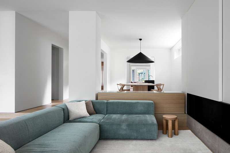 Dossier de presse | 1728-03 - Communiqué de presse | West End Renovation - Akb Architects - Architecture résidentielle - A sectional sofa in the sunken family room faces onto a linear fireplace with a sliding panel above that hides a flat-screen TV. - Crédit photo : Shai Gil