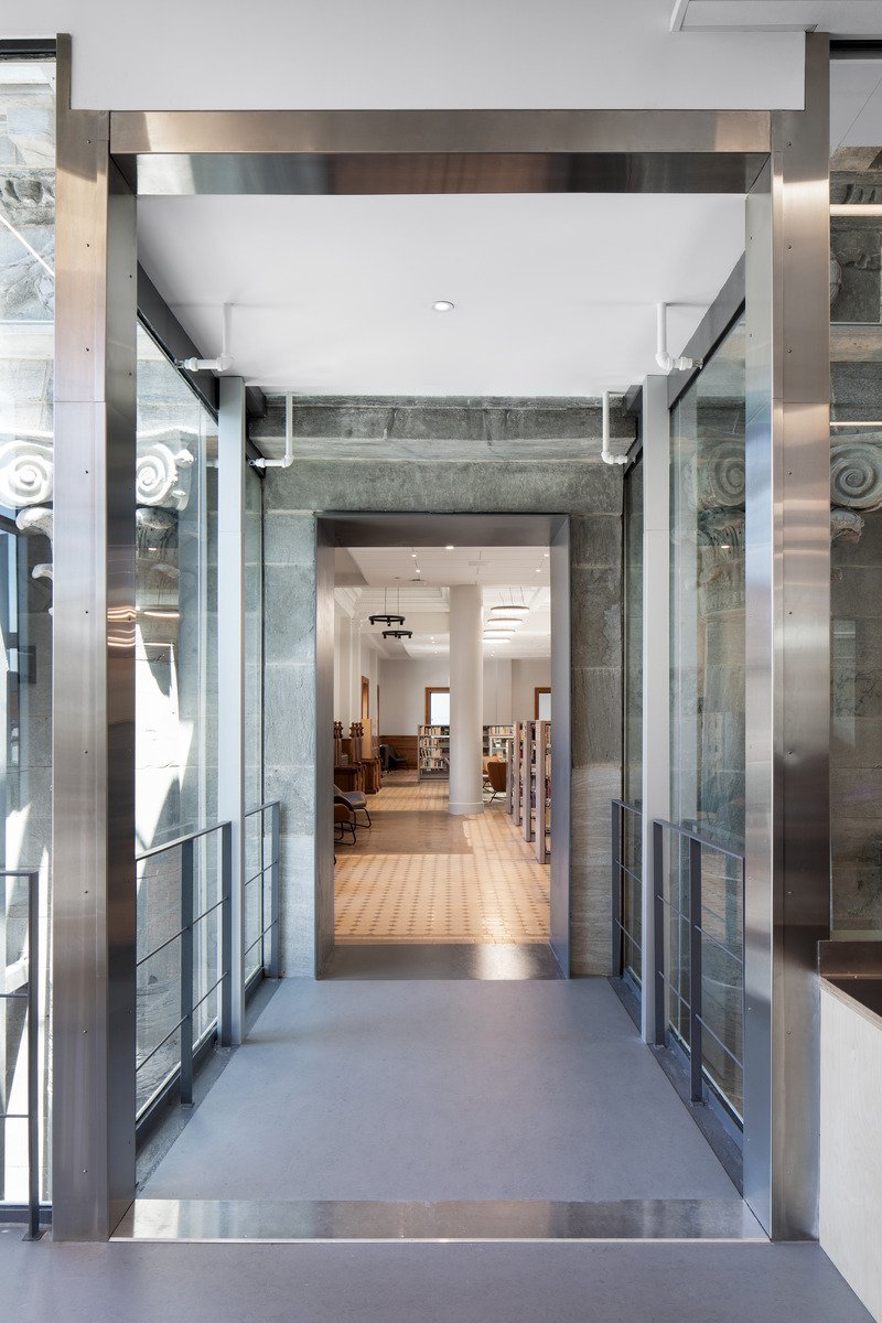 Dossier de presse | 612-23 - Communiqué de presse | La Bibliothèque Maisonneuve : une jolie danse entre deux époques - EVOQ Architecture - Architecture institutionnelle -  Vue d'un portail d'acier avec bâtiment historique en arrière-plan<br> - Crédit photo : Adrien Williams