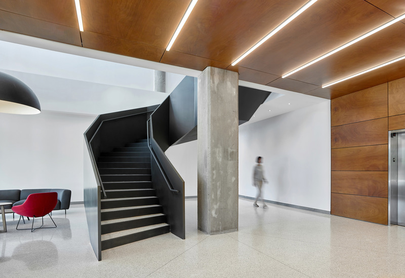 Dossier de presse | 1513-07 - Communiqué de presse | Bata Shoe Factory Revitalization - Dubbeldam Architecture + Design & BDP Quadrangle - Architecture résidentielle - New terrazzo flooring in the public spaces and on the stair treads speaks to the vintage of the building and ensures durability for a high-traffic area. The lobby features a double-height space with a faceted sculptural steel staircase that wraps around an exposed concrete column, highlighting it in place as a homage to the original factory structure.  - Crédit photo : Scott Norsworthy