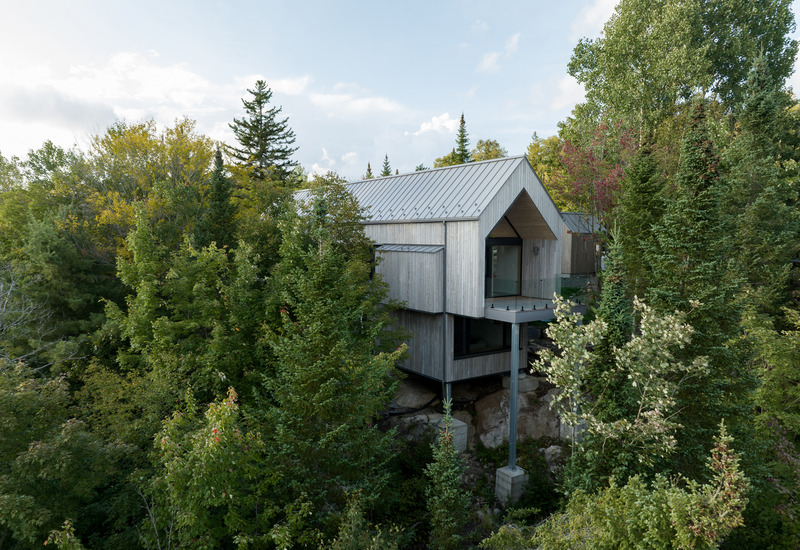Dossier de presse | 2054-04 - Communiqué de presse | Chalet Papillon - RobitailleCurtis - Architecture résidentielle -   Vue du chalet niché dans les arbres, sur un site très escarpé et densément boisé - Crédit photo : Adrien Williams