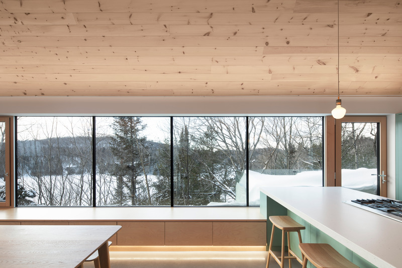 Dossier de presse | 2054-04 - Communiqué de presse | Chalet Papillon - RobitailleCurtis - Architecture résidentielle -  Vue hivernale à travers les arbres des collines au loin; vue vers le Sud-Ouest - Crédit photo : Adrien Williams