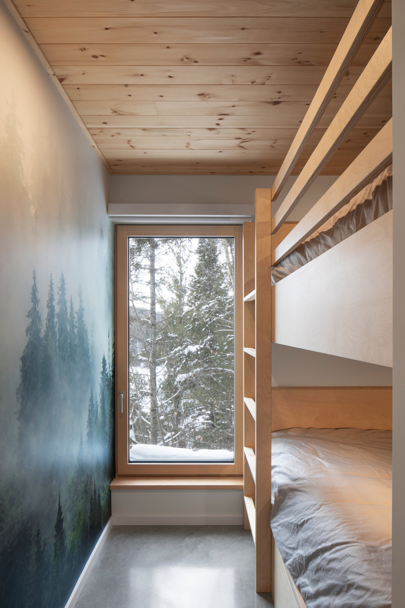 Dossier de presse | 2054-04 - Communiqué de presse | Chalet Papillon - RobitailleCurtis - Architecture résidentielle -  Vue hivernale des lits superposés sur mesure en bois d'érable dans une chambre; vue vers le Sud - Crédit photo : Adrien Williams