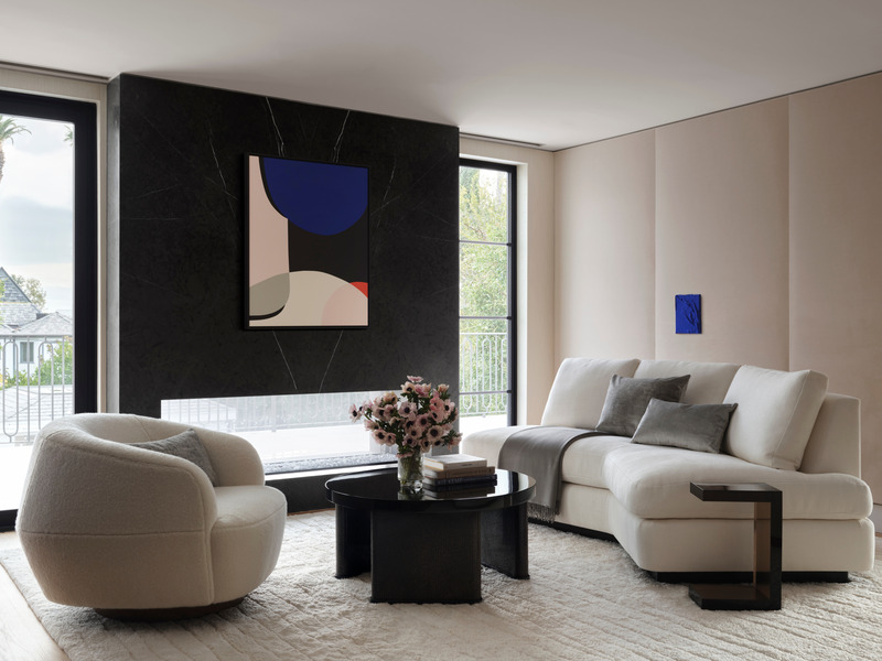 Press kit | 6087-05 - Press release | Palm Residence: A Harmonious Fusion of Hospitality and Home - Daniel Joseph Chenin - Residential Interior Design - Light tones, luscious textiles, and soft furnishings create a sense of calm in the primary  bedroom. Custom armless Angle sofa by A. Rundin is paired with Allan Knight Avalon  occasional table and Holly Hunt Sumo lounge chair. Acrylic on canvas by Francois  Bonnel hangs above the fireplace, complemented by a vividly colored textured piece by  Jeff Peters on the far wall. - Photo credit: Douglas Friedman