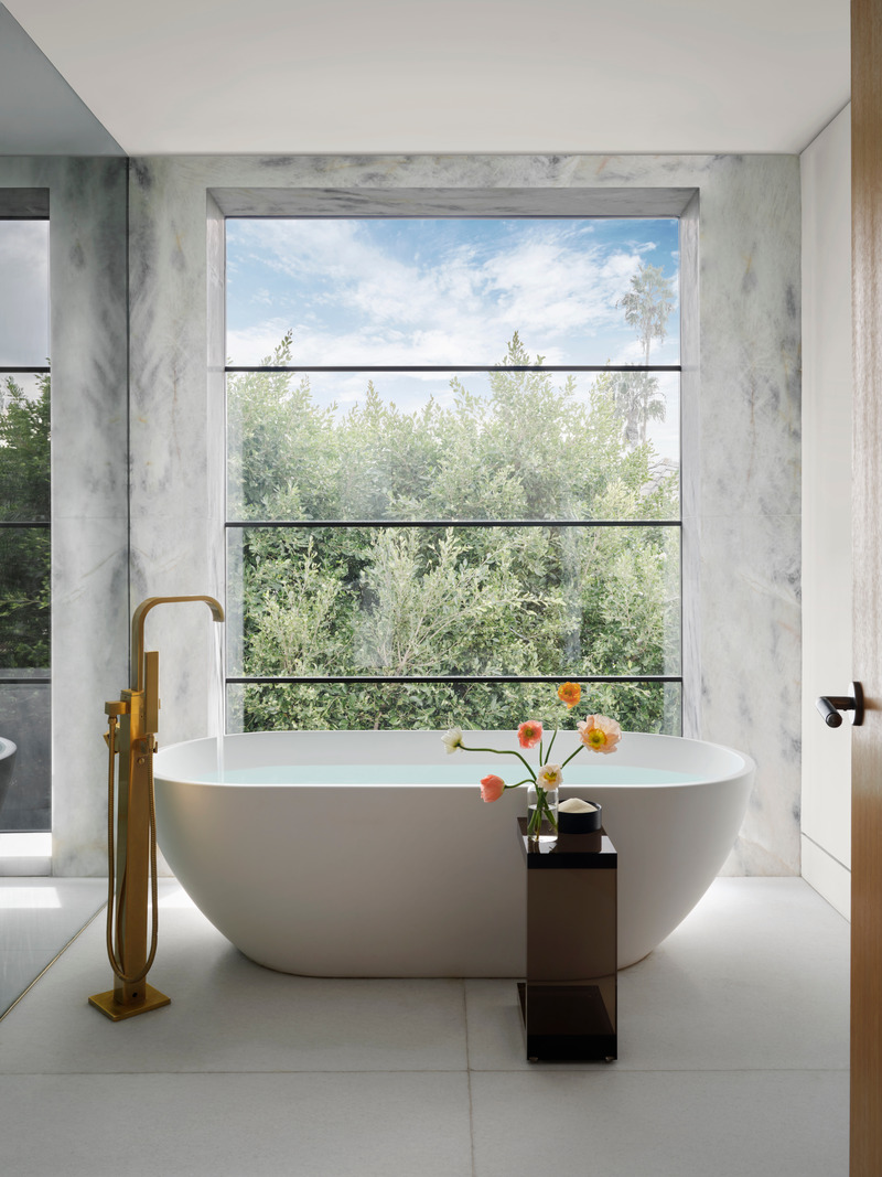 Press kit | 6087-05 - Press release | Palm Residence: A Harmonious Fusion of Hospitality and Home - Daniel Joseph Chenin - Residential Interior Design - Light stone and a freestanding soaking tub with views to the lush surrounding landscape in one of two bathrooms located in the primary suite. - Photo credit: Douglas Friedman