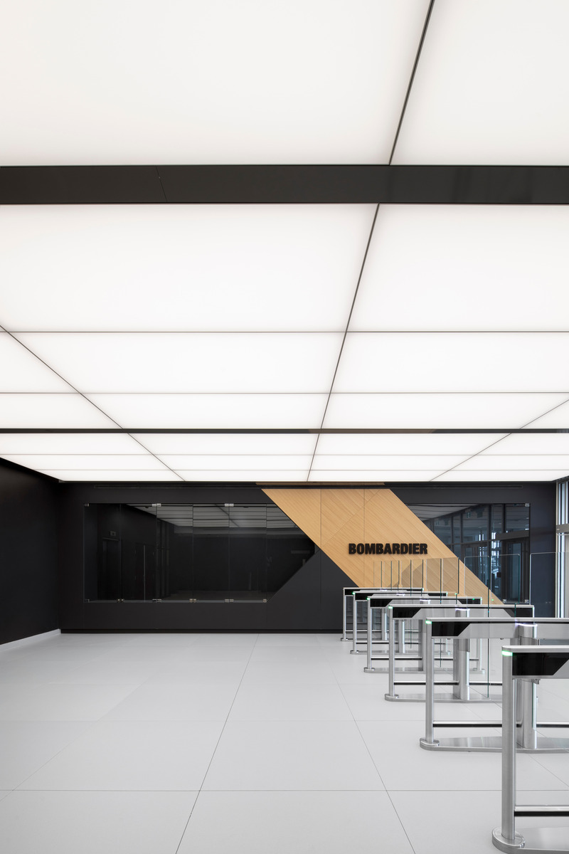 Dossier de presse | 1387-11 - Communiqué de presse | NEUF architect(e)s réalise un nouveau campus aéronautique de hautes technologies sur l’aéroport international Pearson, Toronto - NEUF architect(e)s - Architecture industrielle -  <p class="">Les portiques d'accès contrôlé des employés sont implantés sous un plafond flottant éclairé artificiellement et mettent en œuvre des matériaux contrastés facilitant la circulation et l'orientation.</p>  - Crédit photo : Adrien Williams