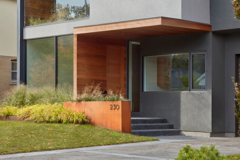 Dossier de presse | 1513-13 - Communiqué de presse | Shift House - Dubbeldam Architecture + Design - Architecture résidentielle - The front facade of the house features a fresh approach to traditional design elements; the home’s entrance is accessed on the side of the foyer volume instead of from the front. A complementary Corten steel planter defines the granite porch and serves as a designated area for displaying the house number.  <br style=""> - Crédit photo : Shai Gil