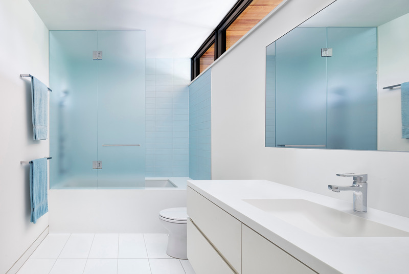 Dossier de presse | 1513-13 - Communiqué de presse | Shift House - Dubbeldam Architecture + Design - Architecture résidentielle - Blue finishes within the principal bathroom echo the materiality present in other areas of the house, while the contrast against the white millwork and flooring imparts a sense of water-like tranquility to the bathing areas. - Crédit photo : Riley Snelling