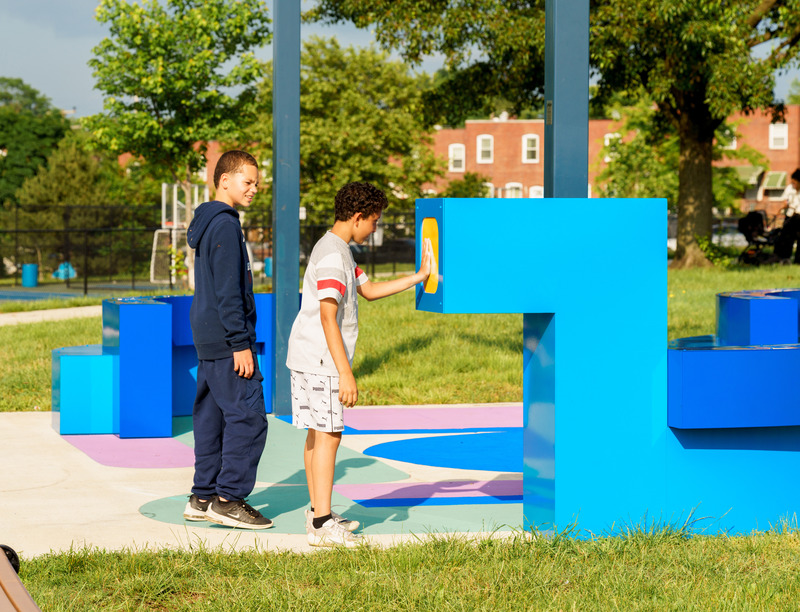 Dossier de presse | 5595-09 - Communiqué de presse | A New Community-Designed Space Evokes Hopeful Conversation in the Brooklyn Neighborhood of South Baltimore - The Urban Conga - Design urbain - Two local kids that helped in the design process  are playing with the view portals. - Crédit photo : Bonnie Newman