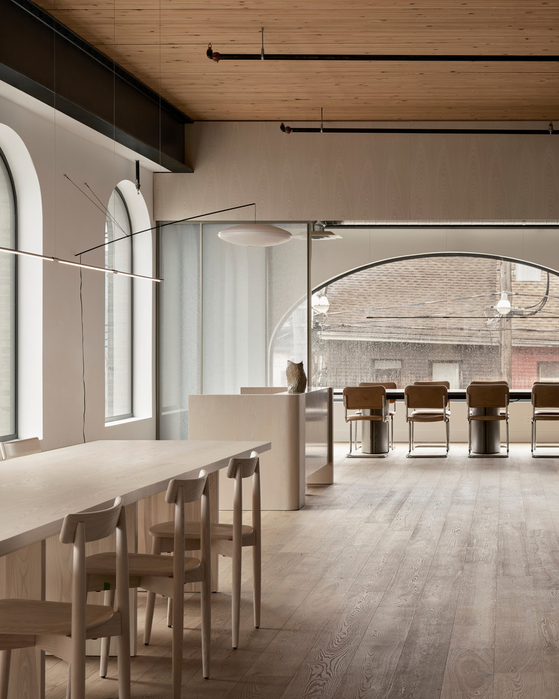 Dossier de presse | 6316-03 - Communiqué de presse | Downtown Film - Ashley Botten Design - Design d’intérieur commercial - A communal harvest table, surrounded by 16 Lara chairs in bleached ash, serves as a workspace, meeting area, dining spot, or for laying out a spectacular party charcuterie. - Crédit photo : Patrick Biller