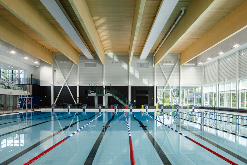 Press kit | 3253-05 - Press release | The Saint-Georges Multisport Complex: Bright and Welcoming - ABCP architecture in consortium with MLL et BBL architects - Institutional Architecture - Over the semi-Olympic pool area, the impressive 34-meter clear-span wooden beams artfully illuminated by the natural light. - Photo credit: Stéphane Groleau