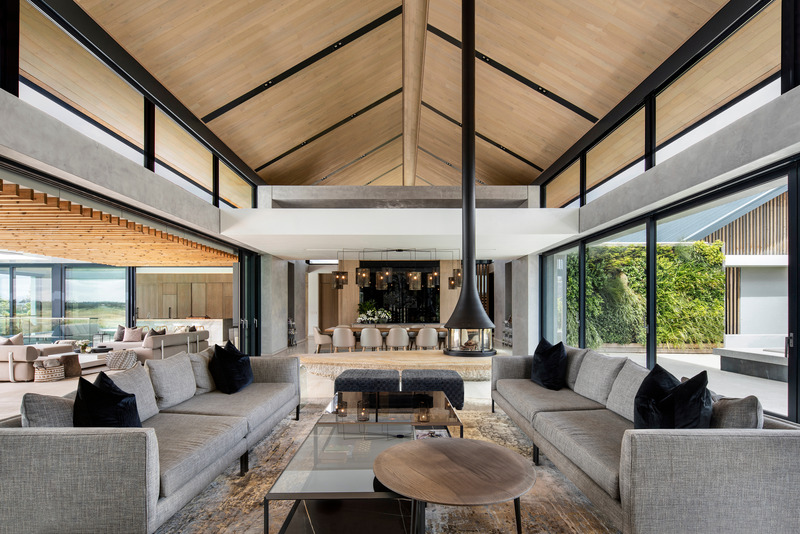 Dossier de presse | 5741-01 - Communiqué de presse | Winelands Villa: Contemporary Blend of Farmhouse & Modern Design - ARRCC - Design d’intérieur résidentiel - <p style="">The double-volume entertainment section features a lounge and dining area. </p><p style=""><br></p><p style="">The pool is situated to the right of the image, and the garden courtyard is featured on the left side.</p> - Crédit photo : Adam Letch