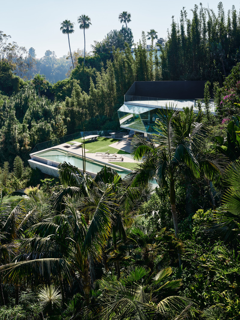 Dossier de presse | 2757-45 - Communiqué de presse | Honoring Architectural Lineage: Conner + Perry Architects Usher in a New Phase for an LA Landmark - Conner + Perry Architects - Architecture résidentielle -   <p class=""><b>Club James:</b> The newly completed accessory complex, Club James, emerges from the lush jungle landscape, its crystalline geometries playing against the surrounding wild flora and bright blue southern California skies.  The infinity tennis court roof sits atop the canted glass enclosure of the office, which floats effortlessly above the lower terrace and pool. </p>   - Crédit photo : Joe Fletcher Photography