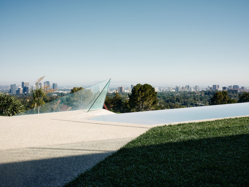 Dossier de presse | 2757-45 - Communiqué de presse | Honoring Architectural Lineage: Conner + Perry Architects Usher in a New Phase for an LA Landmark - Conner + Perry Architects - Architecture résidentielle - <p class=""><b>Lower Terrace Infinity Pool:</b> The pebble concrete deck becomes the pool as a striking glass shard defines the corner overlooking the pool spillway, gardens, and views of the city and Pacific Ocean beyond.</p> - Crédit photo : Joe Fletcher Photography