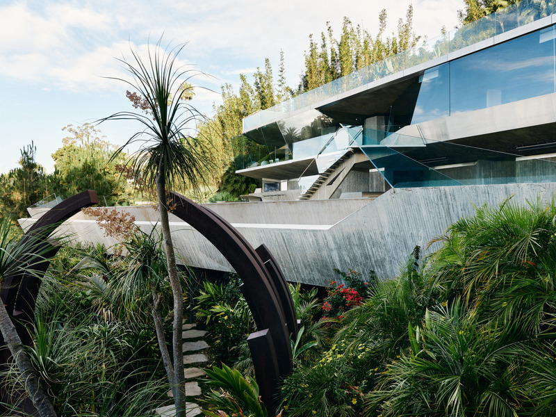 Dossier de presse | 2757-45 - Communiqué de presse | Honoring Architectural Lineage: Conner + Perry Architects Usher in a New Phase for an LA Landmark - Conner + Perry Architects - Architecture résidentielle - <p class=""><b>Club James:</b> View from the lushly planted tropical garden pathway below, looking through the steel Arc sculpture by Bernar Venet, back up at Club James; with its hovering 100-foot-long concrete pool, cantilevered stair up to the nightclub and office level, and the infinity tennis court on the roof. </p> - Crédit photo : Joe Fletcher Photography