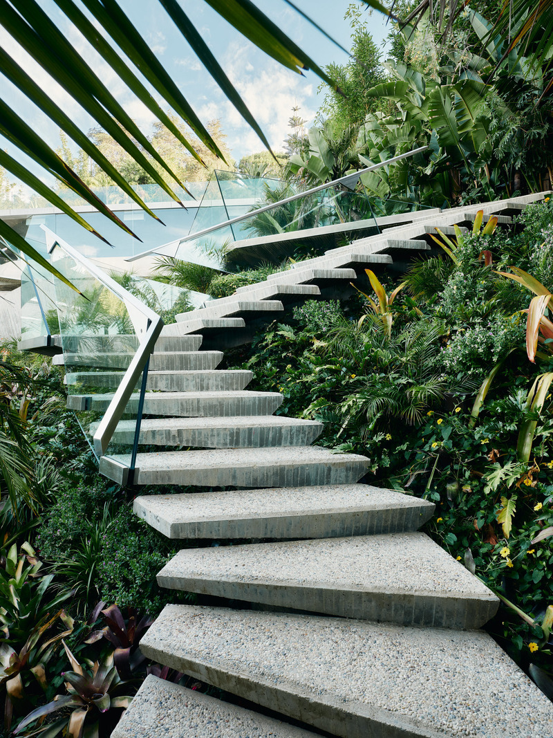 Dossier de presse | 2757-45 - Communiqué de presse | Honoring Architectural Lineage: Conner + Perry Architects Usher in a New Phase for an LA Landmark - Conner + Perry Architects - Architecture résidentielle - <p class=""><b>Lower Terrace Stair:</b> A concrete cantilevered stair winds from the terrace level down into the lush gardens below.  As the architecture reaches out into the landscape it becomes more dynamic responding to the topography and wild fauna.  The angular stainless-steel handrail floats above the structure supported only by frameless glass stanchions.</p> - Crédit photo : Joe Fletcher Photography