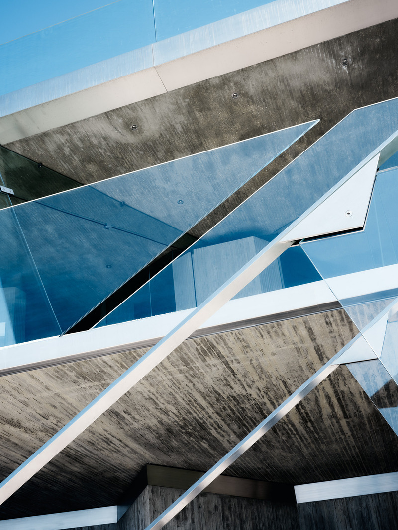 Dossier de presse | 2757-45 - Communiqué de presse | Honoring Architectural Lineage: Conner + Perry Architects Usher in a New Phase for an LA Landmark - Conner + Perry Architects - Architecture résidentielle - <p class=""><b>Lower Terrace Stair Detail:</b> The stainless-steel handrail seems to delicately hover in mid-air, supported only by the frameless glass guardrails.  The project’s characteristic board-formed concrete provides a substantive yet refined backdrop for their dramatic angular geometries.</p> - Crédit photo : Joe Fletcher Photography