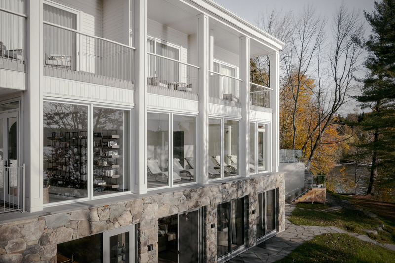 Dossier de presse | 2603-03 - Communiqué de presse | Le Spa à Manoir Hovey - LAMAS Architecture Ltd - Architecture commerciale - Façade côté lac du bâtiment du spa avec des murs en pierre des champs au niveau du sol - Crédit photo :  Félix Michaud 