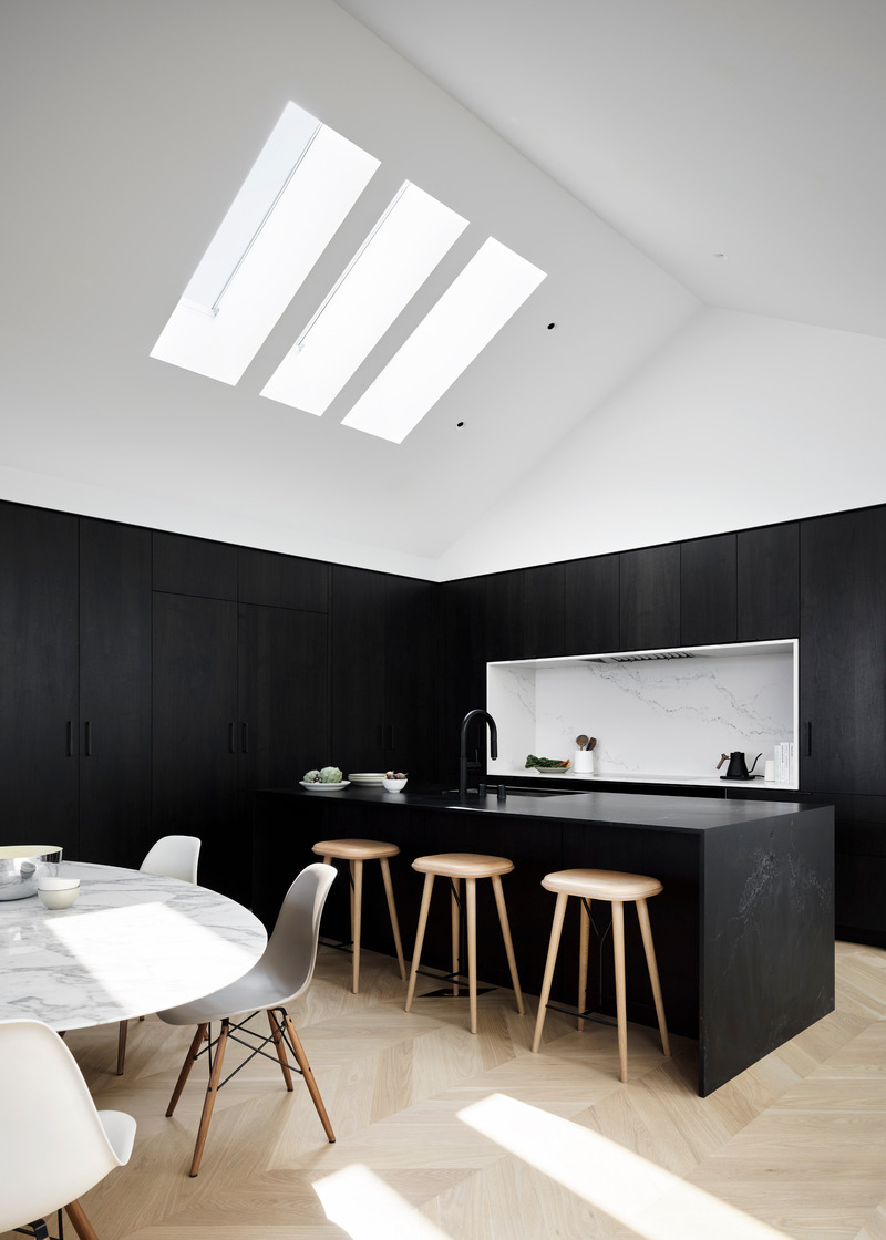 Dossier de presse | 2757-46 - Communiqué de presse | WDA's House of Light and Shadow Defines Contemporary Urban Living - William Duff Architects (WDA) - Architecture résidentielle - <p>In the kitchen and dining area, black walnut cabinetry by Seattle-based Henrybuilt sits dramatically below the white peaked roof. The Empira Black honed quartz used for the island and the Statuario Nuovo honed quartz which wraps the cooktop are from Caesarstone.</p> - Crédit photo :  Matthew Millman with Lucy Bamman (stylist) 