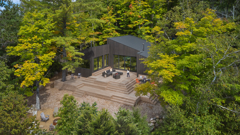 Dossier de presse | 1513-14 - Communiqué de presse | Catchacoma Cottage - Dubbeldam Architecture + Design - Architecture résidentielle - <p class="">An expansive deck spans multiple levels, bridging the sloped site's grade differences and cascading down in multiple tiers towards the water's edge. Extending along the lakeside of the cottage, it offers diverse gathering spots for family gatherings or individual outdoor relaxation.</p> - Crédit photo : Riley Snelling